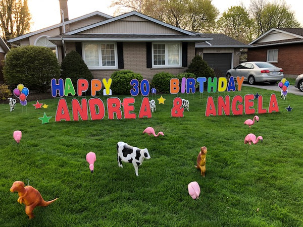 Yard signs with flamingos, cows and dinosaur ornaments